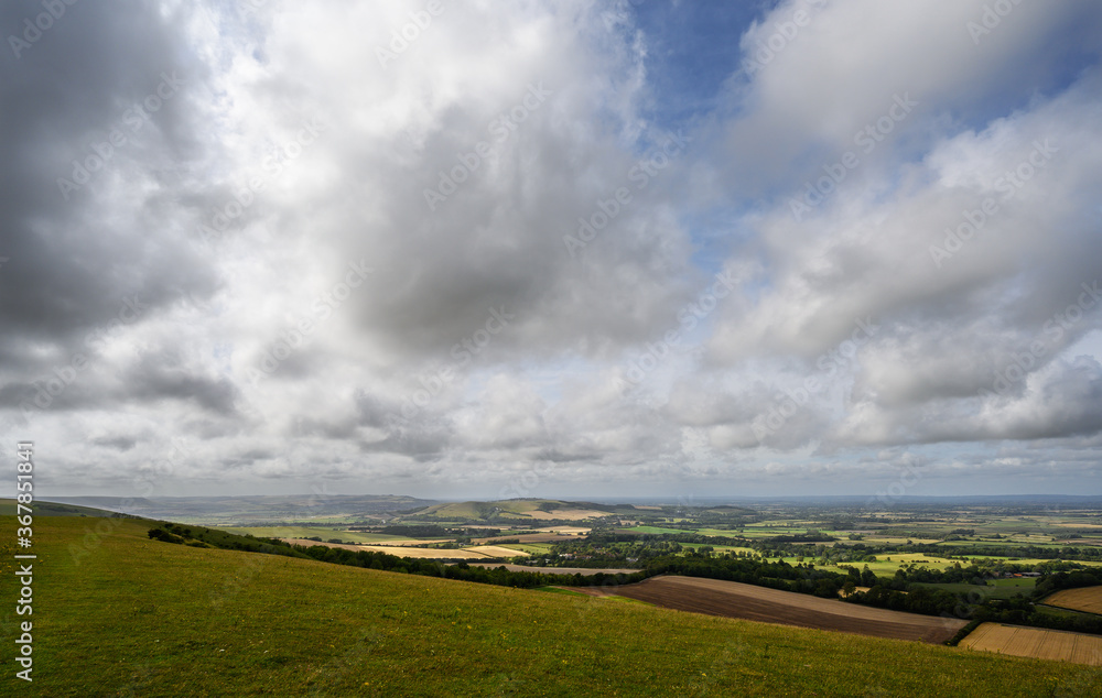 South Downs National Park, Sussex, UK near Firle Beacon. Views over the Weald with sunshine and clouds seen from the South Downs Way. The South Downs Way is a national trail popular with walkers.