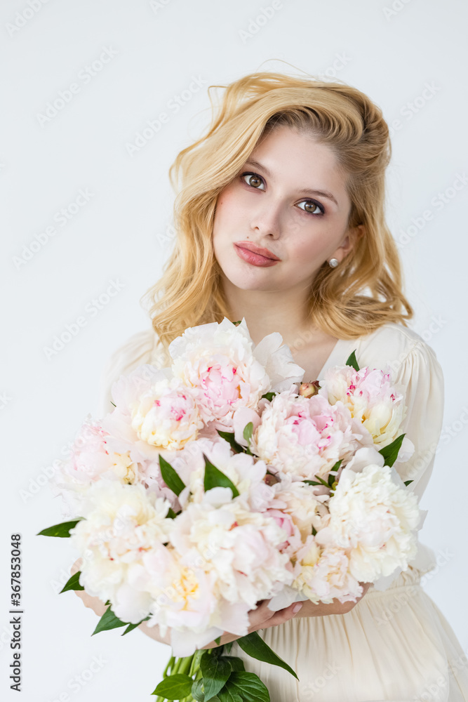 beautiful sensual girl with long blonde hair in dress with a bouquet of pink peonies flowers. Сoncept of feminity beautiful sensual girl with long blonde hair in dress with a bouquet of pink peonies flowers. Сoncept of feminity