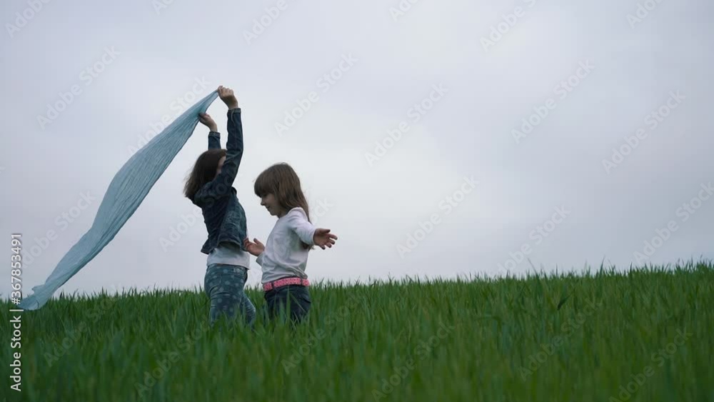 Two girls in a wheat field. The concept of a carefree happy childhood Two girls in a wheat field. The concept of a carefree happy childhood