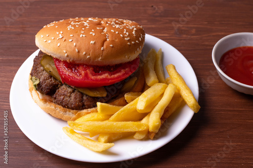 french fries and a burger on wooden surface