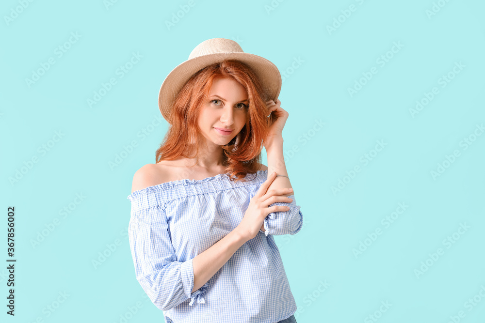 Beautiful young redhead woman on color background