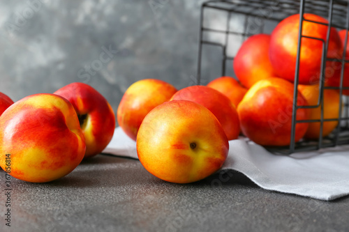 Photos Overturned basket and scattered nectarines on grey background