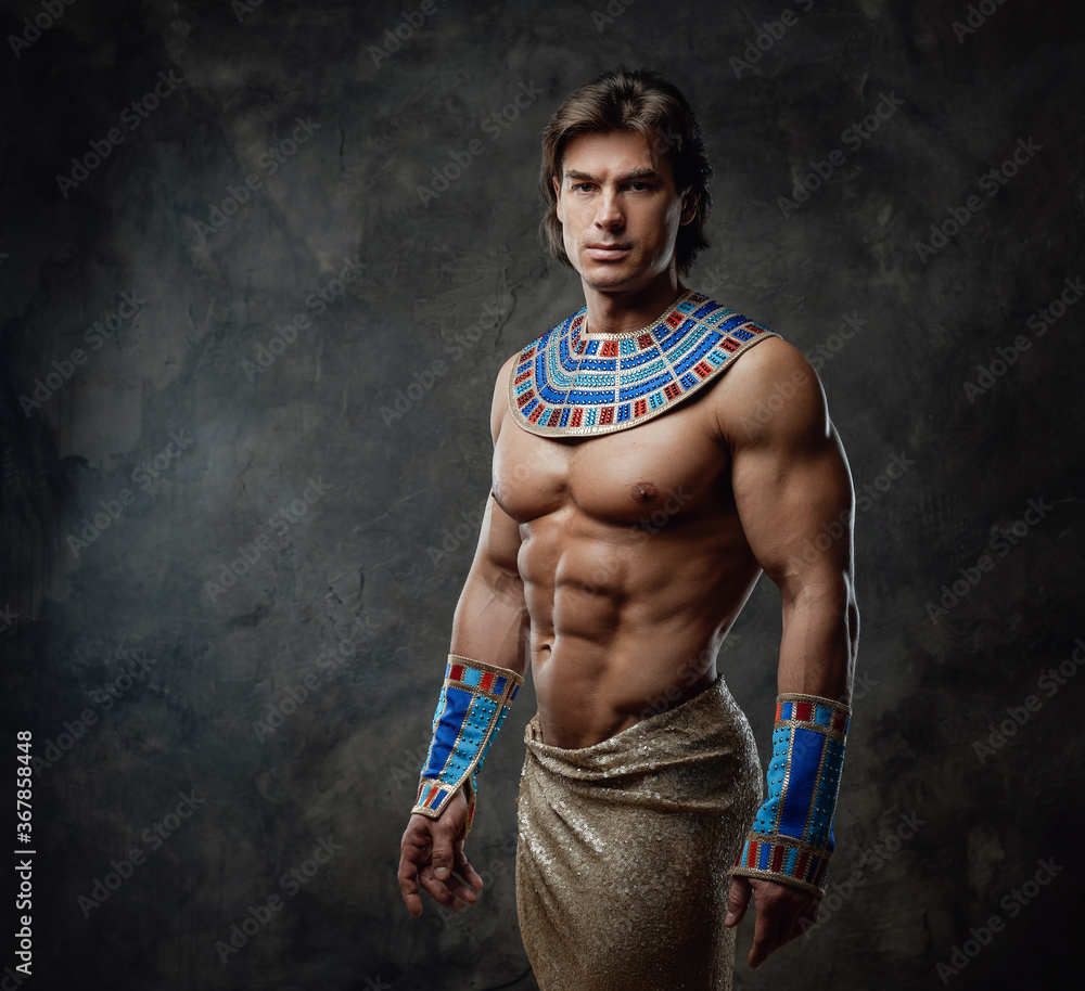 Athletic and very sexy man in representative egyptian costume posing in the  studio with dark walls foto de Stock | Adobe Stock