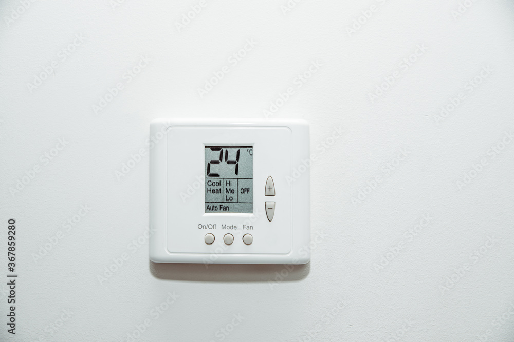 Air conditioner in the room. The concept of cooling the apartment on warm days. White panel for temperature control in a room, office. Air conditioner in the room. The concept of cooling the apartment on warm days. White panel for temperature control in a room, office.
