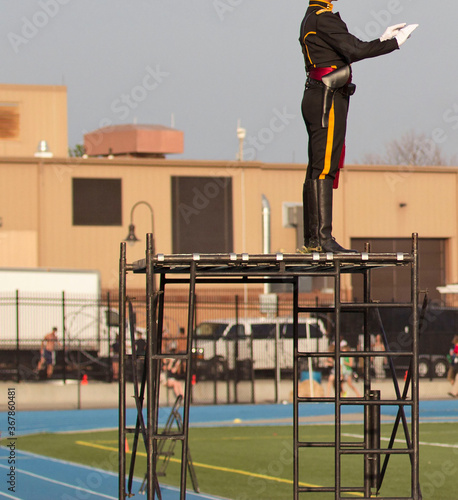 Drum major leading a marching band playing musical instruments on a field