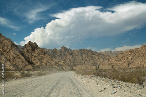 Geological sandstone hills. Traveling along the dirt road across the desert valley and rocky mountains. 