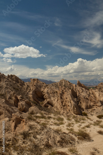 Desert landscape. Geology. View of the arid valley, sandstone and rocky formations under a beautiful blue sky.