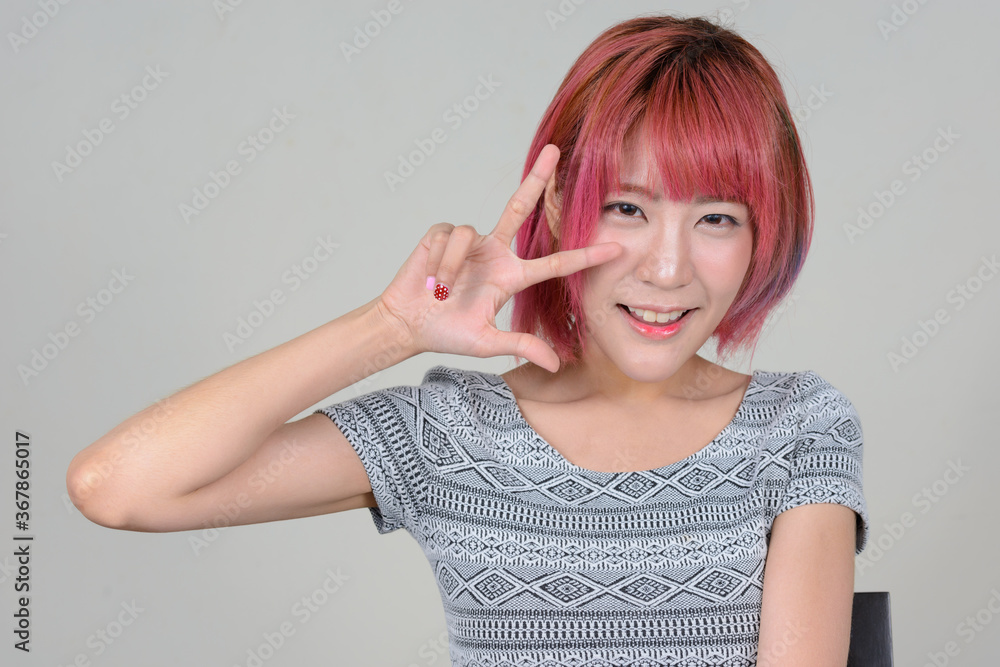 Young beautiful Asian woman with pink hair Young beautiful Asian woman with pink hair