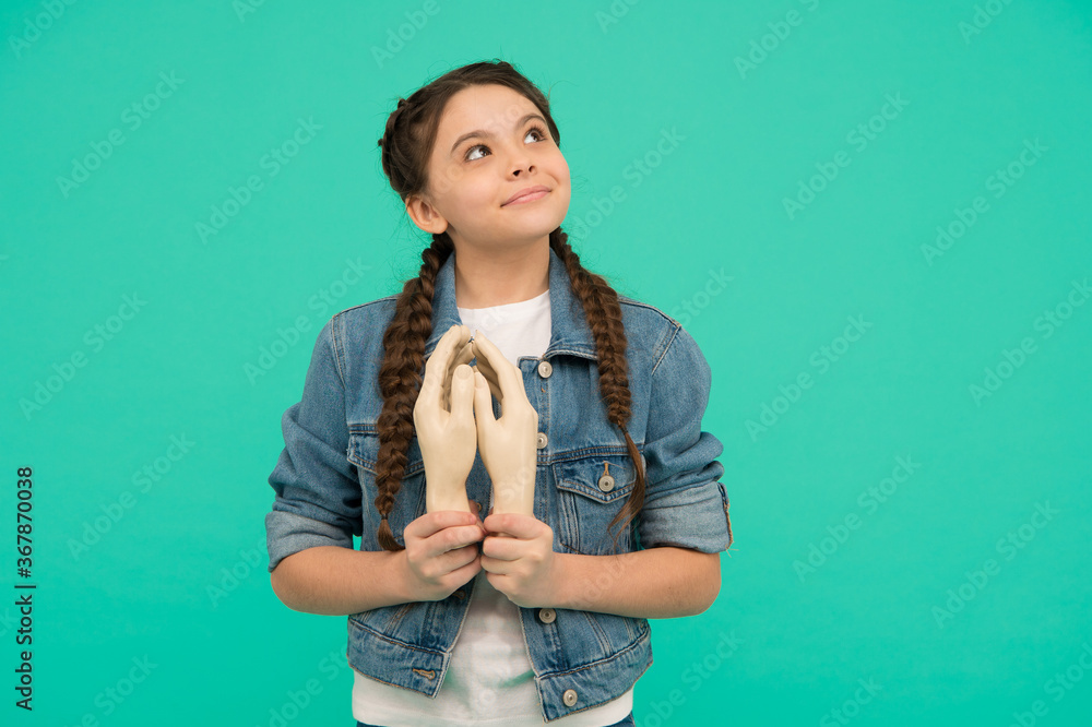 Chase your dreams. Small prayer blue background. Little girl hold artificial praying hands