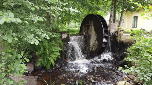 Old wooden water wheel and dam on small creek.