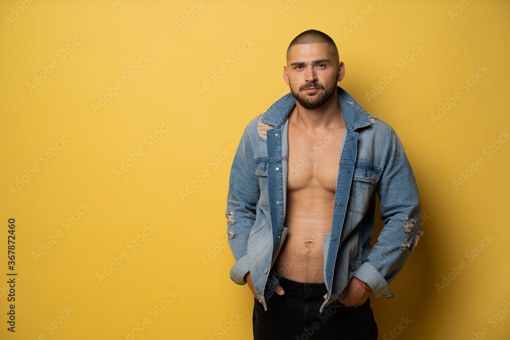 Obraz premium brutalny mężczyzna z czarną brodą i modną fryzurą fryzjerską zostaje sfotografowany w studiu fotograficznym