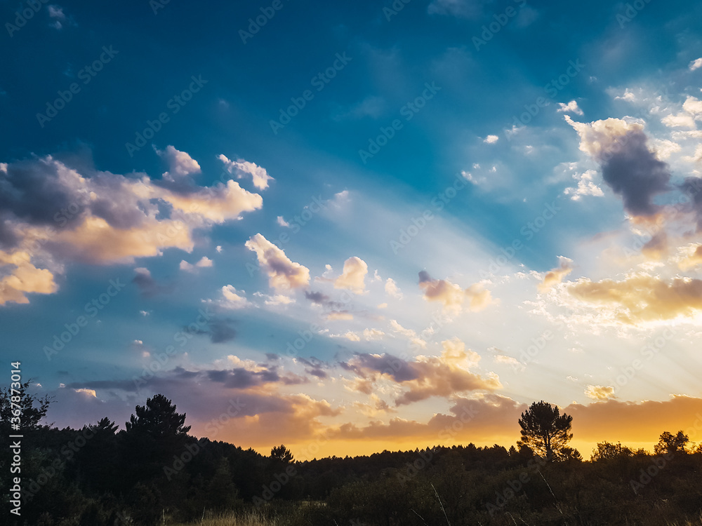 Beautiful sunlight through the clouds on a summer sunset