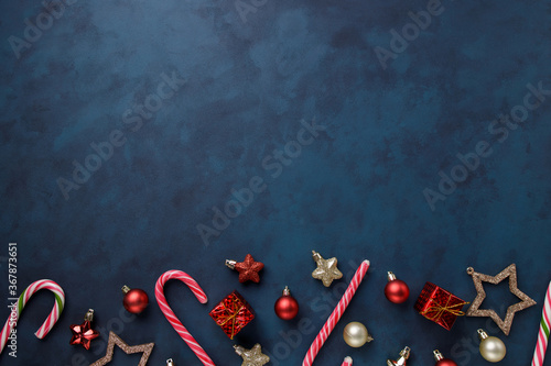 Christmas and New Year celebration traditions concept. Composition of festive decorations, candies and gift boxes on dark background with copy space for text design