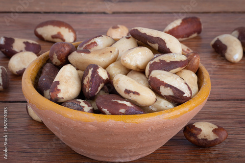Brazilian nut, known as "Castanha do Pará" in a bowl on a wooden background.