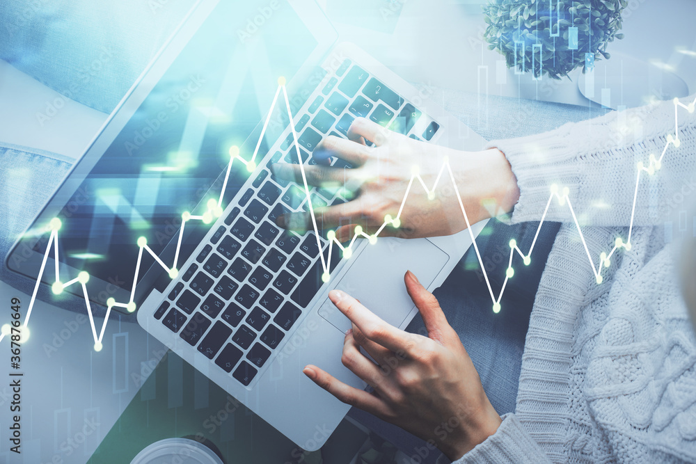 Double exposure of woman hands working on computer and forex chart hologram drawing. Top View. Financial analysis concept. Double exposure of woman hands working on computer and forex chart hologram drawing. Top View. Financial analysis concept.