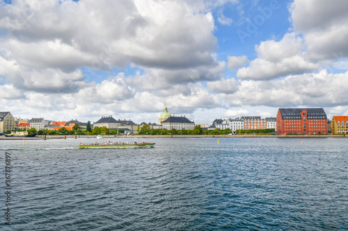Canvas Print A tourist cruise boat floats past Amalienborg castle and the Marble or Frederik's Church on the water near Holmen Island harbor in Copenhagen Denmark