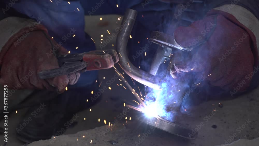 Close-up welder working with electrode at semi-automatic arc welding in ...