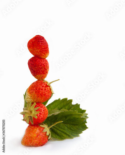 Fototapeta Naklejka Na Ścianę i Meble -  Strawberry fruits are arranged in a column with a green leaf, isolated on a white background