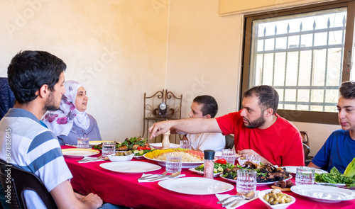 Happy arabic muslim family eating together in a family meeting f