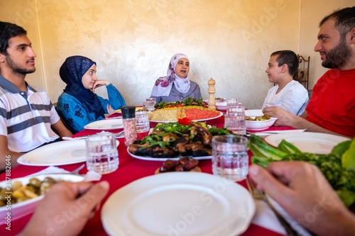 Happy arabic muslim family eating together in a family meeting