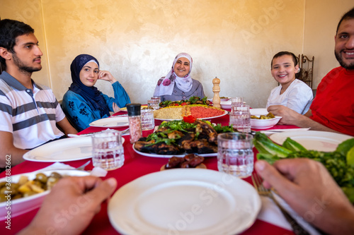 Happy arabic muslim family eating together in a family meeting
