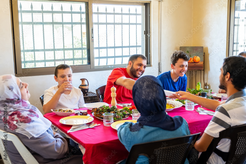 Arabic muslim family eating together in a meeting for iftar in ramadan Arabic muslim family eating together in a meeting for iftar in ramadan