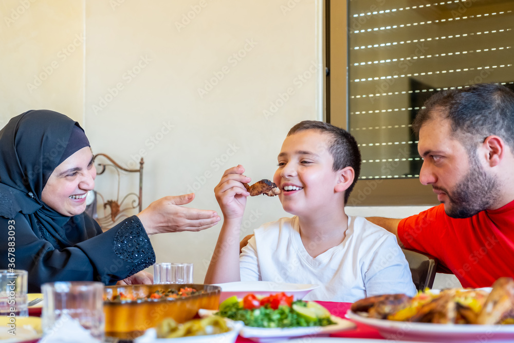 Arabic muslim family eating together in a meeting for iftar in r Arabic muslim family eating together in a meeting for iftar in r