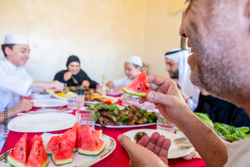 Happy arabic muslim family eating together in a family meeting for iftar in ramadan Happy arabic muslim family eating together in a family meeting for iftar in ramadan