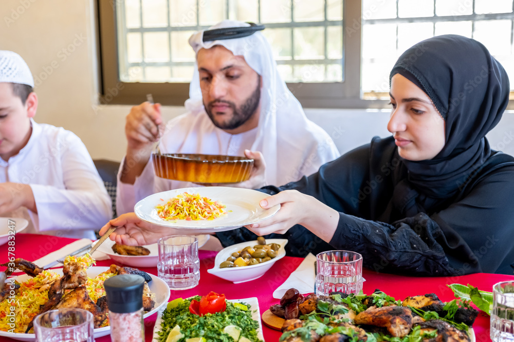 Happy arabic muslim family eating together in a family meeting f Happy arabic muslim family eating together in a family meeting f