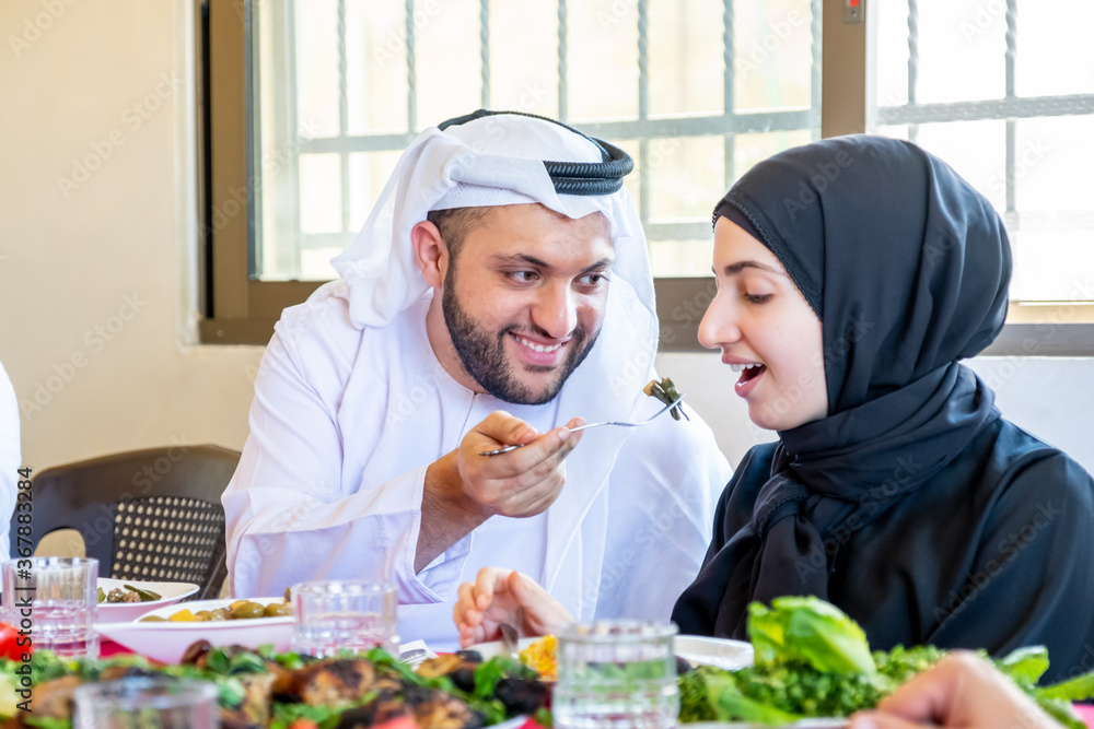 Arabic muslim husband feeding his wife some food Arabic muslim husband feeding his wife some food