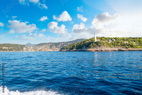 View from the Mediterranean Sea of the Saint Jean Cap Ferrat lighthouse as the sun begins to set on the French Riviera in the South of France.