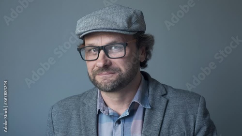 portrait of a handsome Cheerful joyful young man y  in cap smiling and winking provocative to the camera