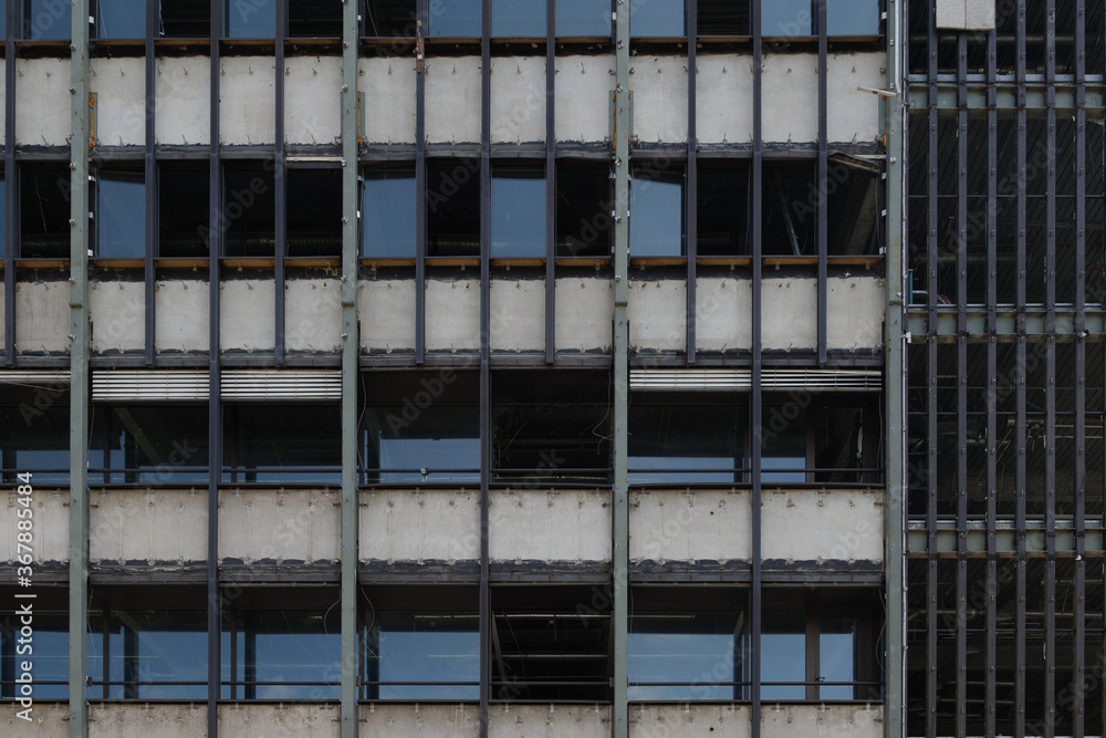 Front view of remaining typical modern facade of office Building demolition. Demolished construction site in the city.