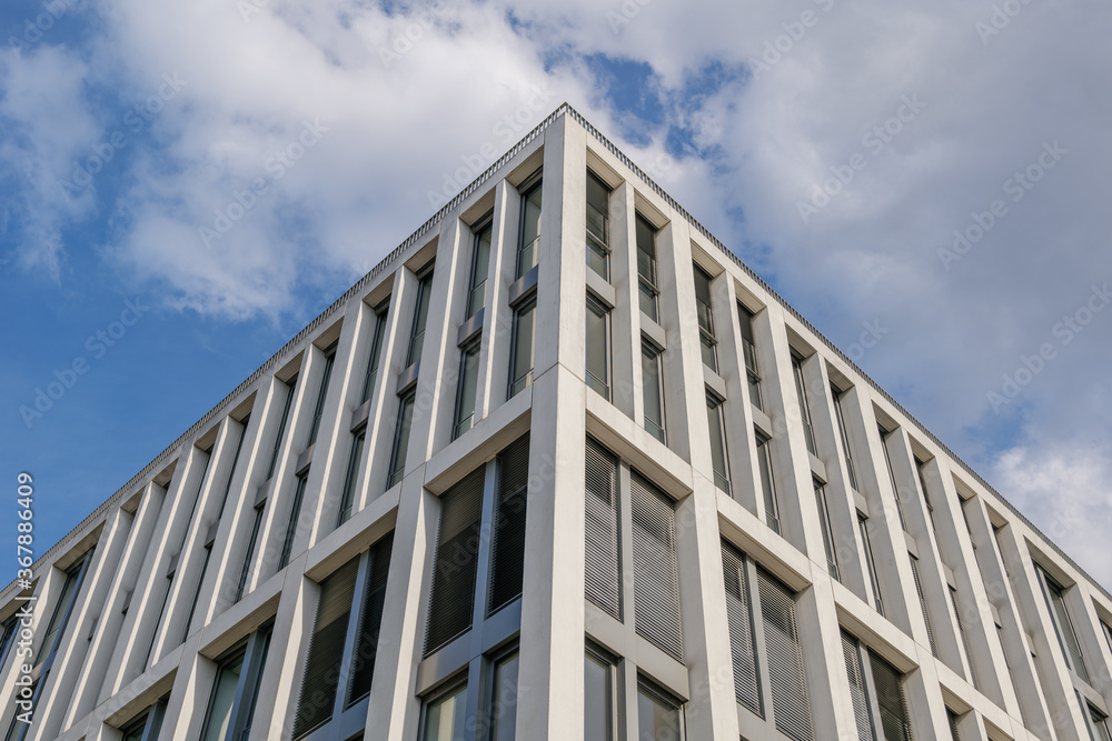 Close up detail at corner of white cladding facade with rectangular windows and reflected glass of modern office building. Abstract Typical Architectural Geometry elements background. Close up detail at corner of white cladding facade with rectangular windows and reflected glass of modern office building. Abstract Typical Architectural Geometry elements background.