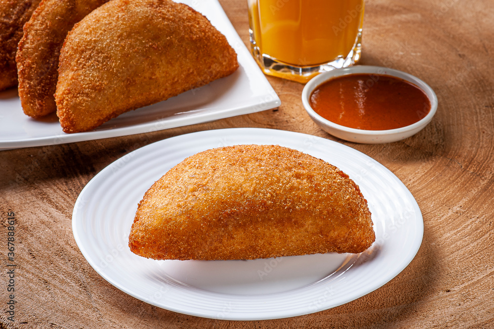 Brazilian appetizer deep fried beef croquette with pepper sauce and orange juice - Risolis
