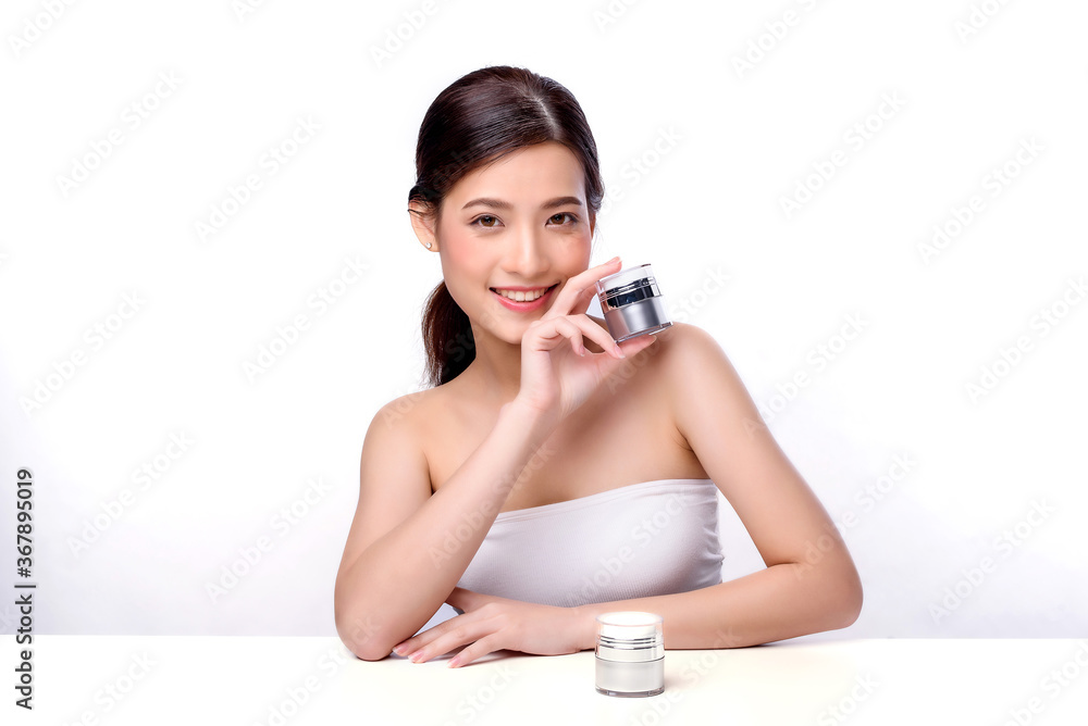 Portrait of beautiful charming young Asian woman posing facial with cosmetic and sitting with white table, beauty of female face with skincare on white background, healthcare and skin care concept. Portrait of beautiful charming young Asian woman posing facial with cosmetic and sitting with white table, beauty of female face with skincare on white background, healthcare and skin care concept.