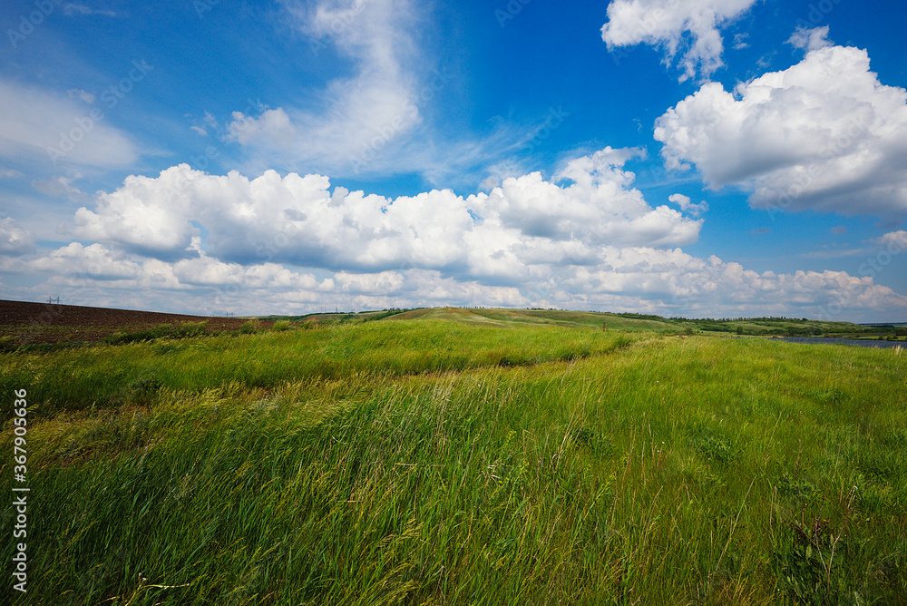 Summer natural landscape, meadow, field, hills. Beautiful blue sky with clouds. Summer natural landscape, meadow, field, hills. Beautiful blue sky with clouds.