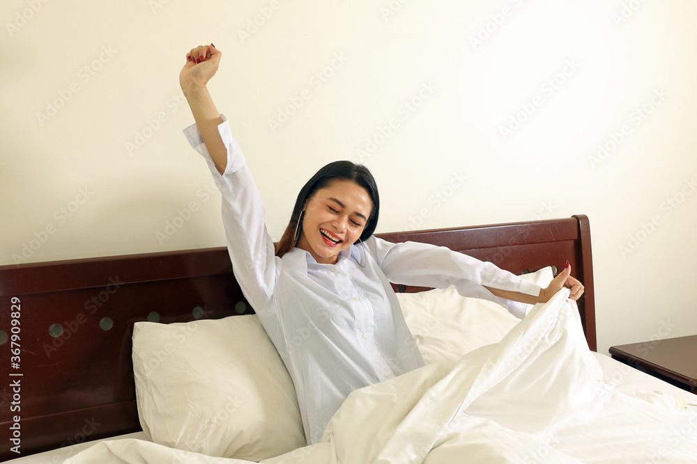 Young beautiful modern Malay woman relax morning wake up on bed smile arms in air stretch Young beautiful modern Malay woman relax morning wake up on bed smile arms in air stretch