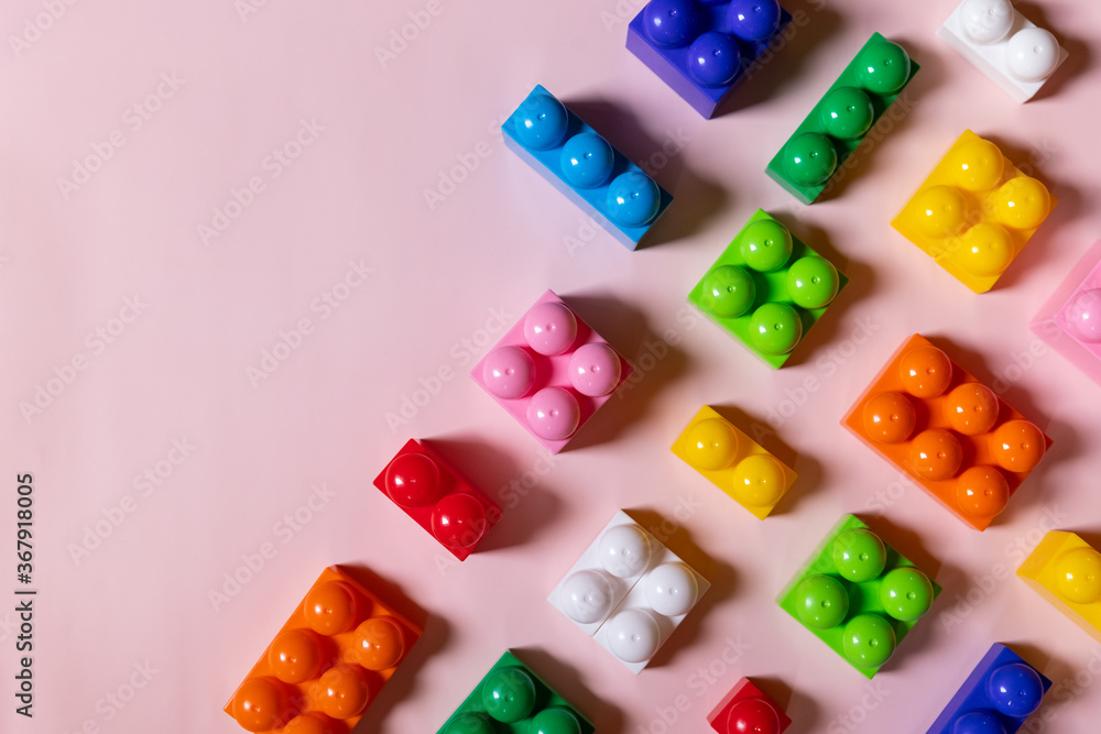 Toys blocks frame,vivid plastic building bricks, group of colorful game pieces.Colorful baby toys on pink background. developing blocks. Creative, logical thinking concept. Flat lay. Copy space. Toys blocks frame,vivid plastic building bricks, group of colorful game pieces.Colorful baby toys on pink background. developing blocks. Creative, logical thinking concept. Flat lay. Copy space.