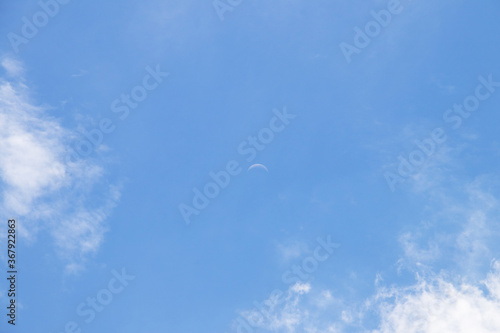 Crescent moon on blue sky. Look like a smile on a good day.