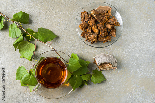 Natural, organic tea made from chaga mushrooms. Increases immunity, the infusion is able to slow down the growth of malignant tumors. View from above. Light gray stone background