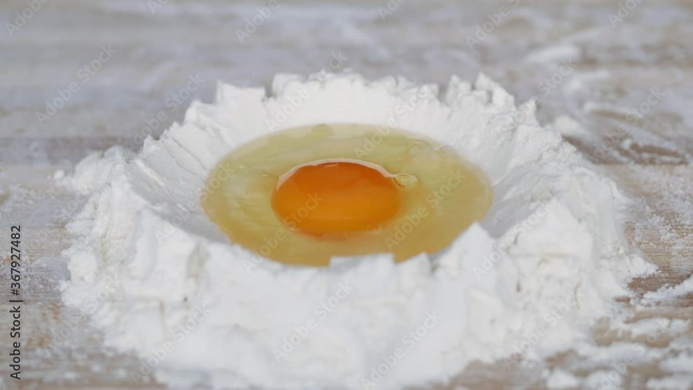 Baker Mix White Flour with a Fresh Egg on the Table Preparing the Dough for Bread in a Bakery Baker Mix White Flour with a Fresh Egg on the Table Preparing the Dough for Bread in a Bakery