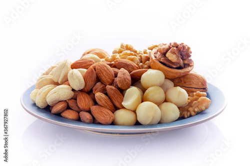 Nutritious mixed nuts on the plate, walnuts, almonds, cashews, macadamia nuts