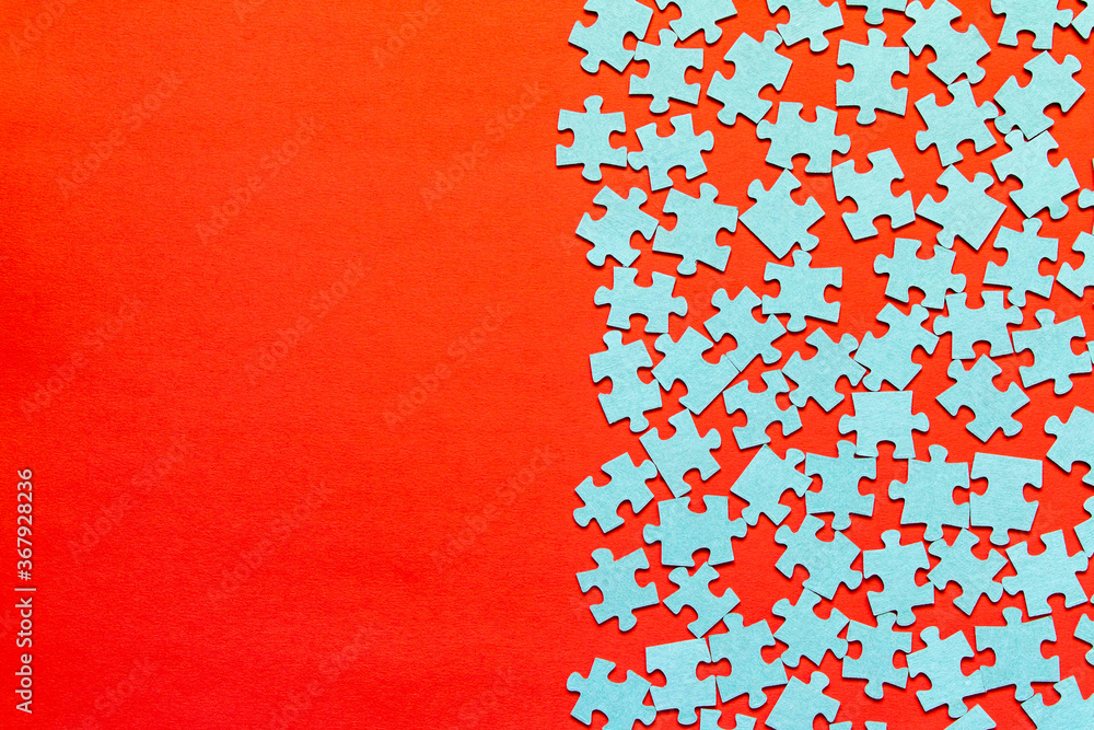 Puzzle. Many puzzle pieces on a red background. The concept of collective thinking. Puzzle. Many puzzle pieces on a red background. The concept of collective thinking.