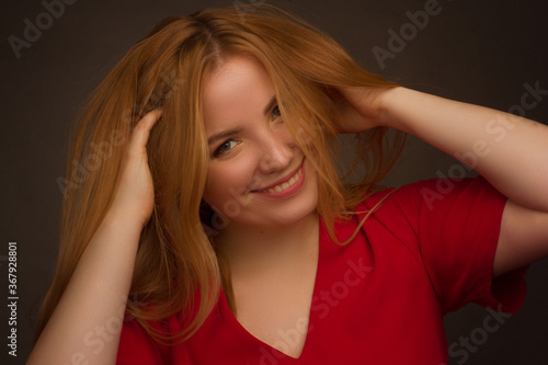 Studio portrait of an overweight young woman with light hair on a black background