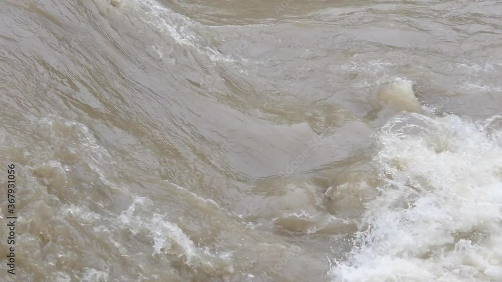 Current section of a muddy highwater river in slow motion Current section of a muddy highwater river in slow motion