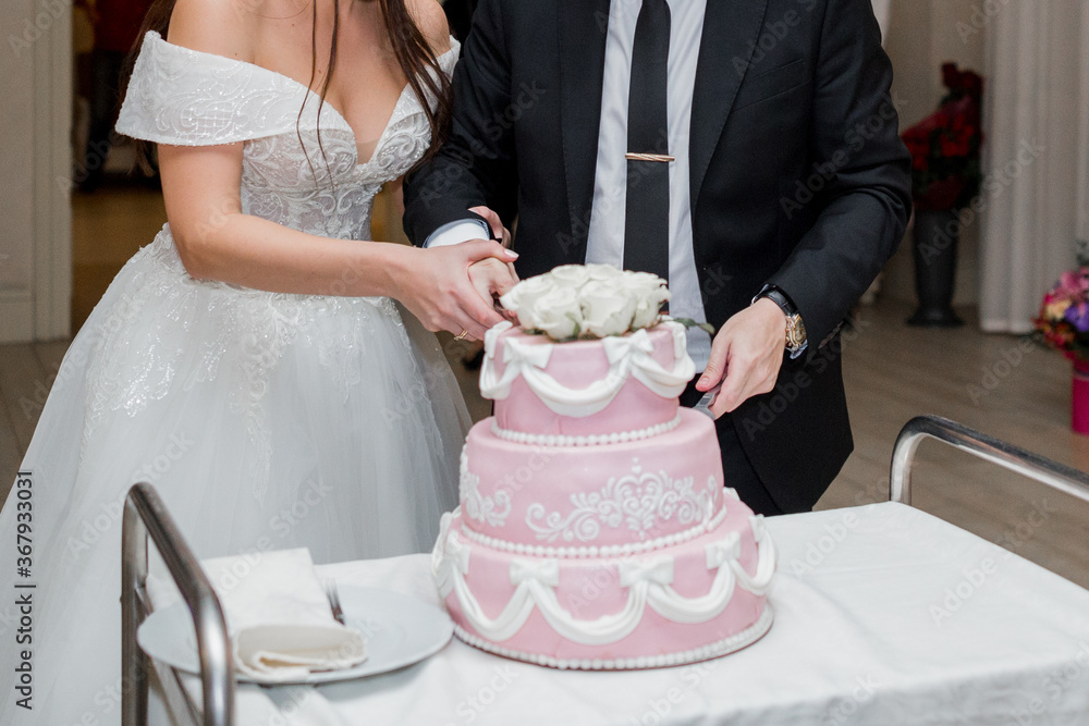 the groom and the bride cut the wedding cake the groom and the bride cut the wedding cake