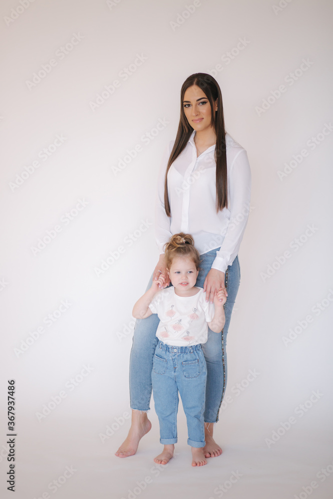 Little girl with mom in studio. White background Little girl with mom in studio. White background