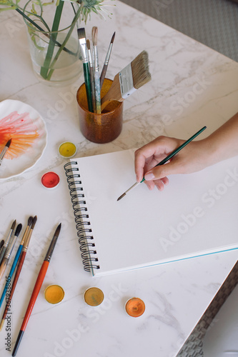 Blank white paper for watercolor and artistic tools on modern workspace. 