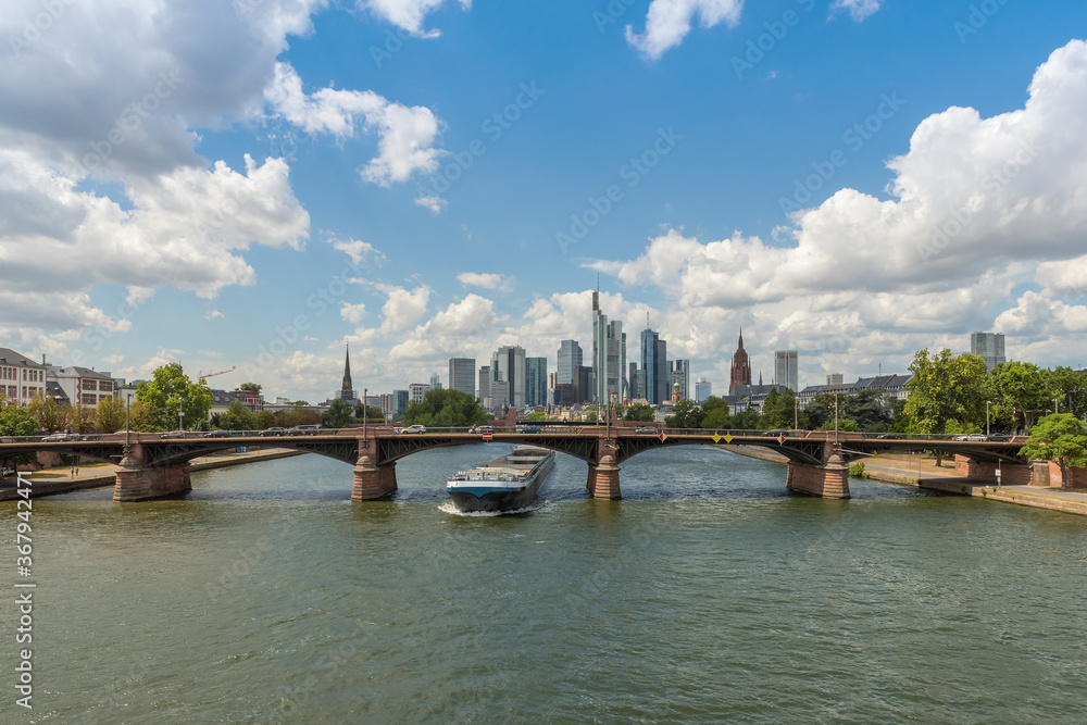 Obraz premium Large barge moving upstream in front of the skyline, Frankfurt, Germany
